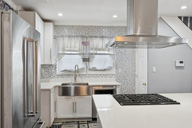 kitchen featuring black gas stovetop, a sink, light countertops, freestanding refrigerator, and island exhaust hood