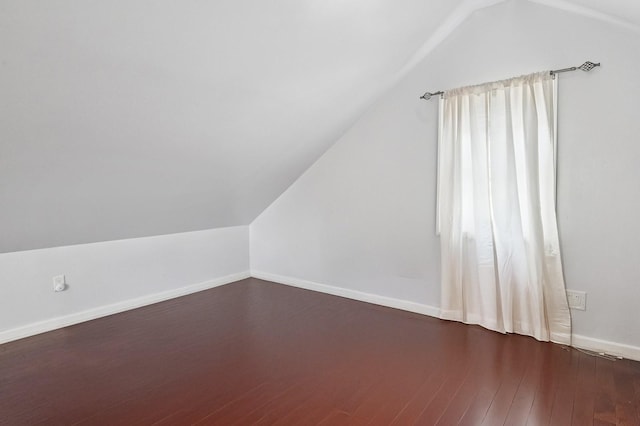 bonus room with lofted ceiling, baseboards, and dark wood finished floors