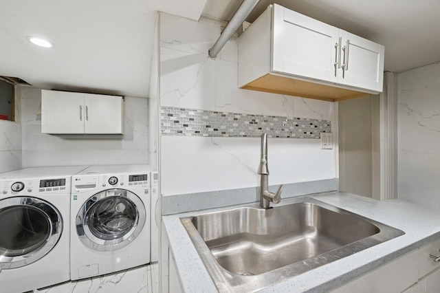 clothes washing area featuring marble finish floor, washing machine and dryer, a sink, and recessed lighting