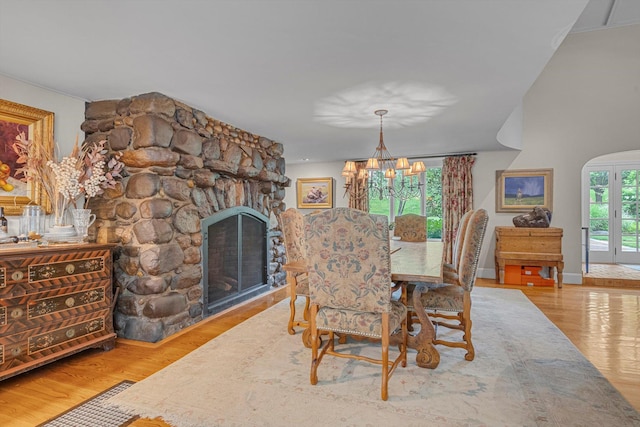 2 Aspen Pl, Great Neck, NY 11021 - dining area with a chandelier, wood finished floors, a stone fireplace, and baseboards