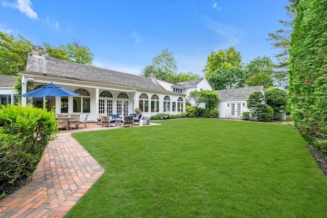 2 Aspen Pl, Great Neck, NY 11021 - back of property with french doors, a lawn, a chimney, and a patio area