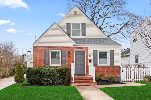 bungalow with brick siding, roof with shingles, a gate, fence, and a front yard