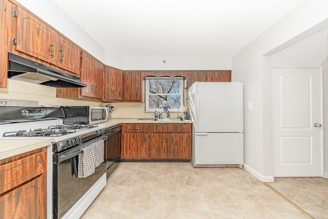 kitchen featuring freestanding refrigerator, light countertops, under cabinet range hood, dishwasher, and gas range