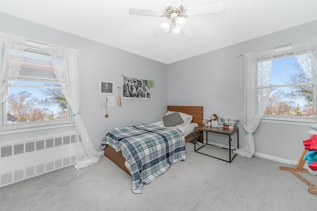 bedroom with a ceiling fan, radiator heating unit, baseboards, and carpet floors