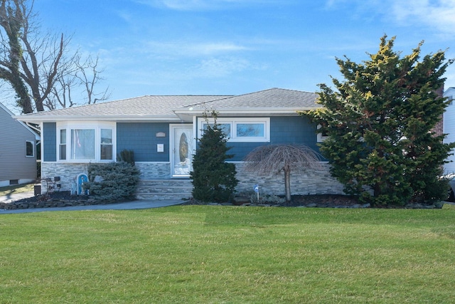 view of front facade featuring stone siding, roof with shingles, and a front yard