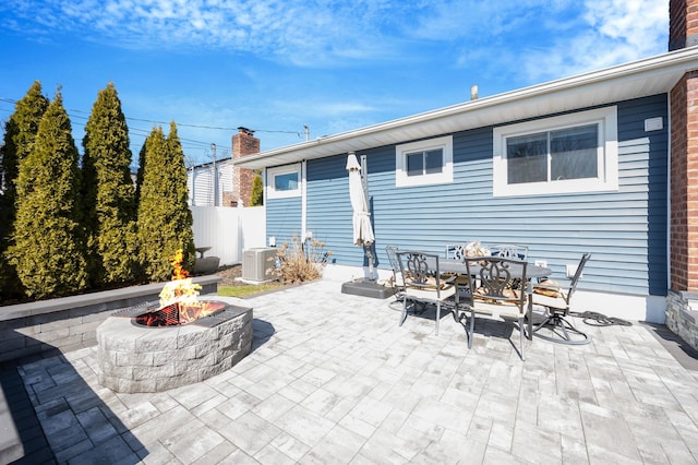 view of patio featuring a fire pit, cooling unit, and fence