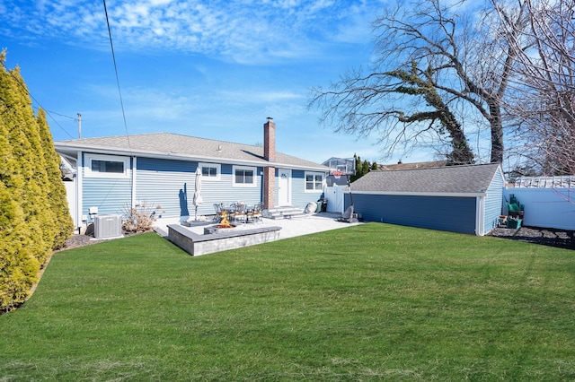 rear view of house with an outbuilding, a yard, a chimney, and entry steps