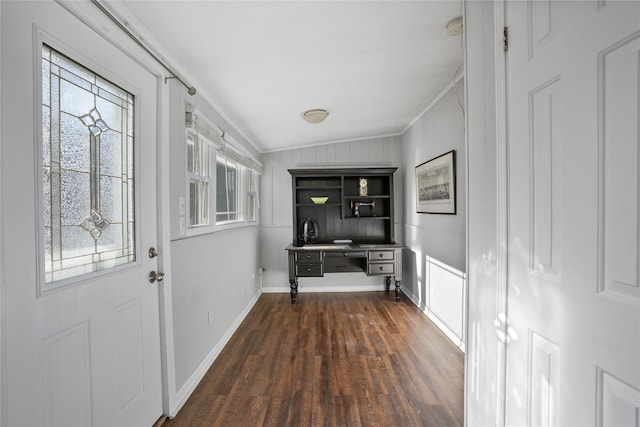 interior space with baseboards, dark wood-style flooring, and ornamental molding