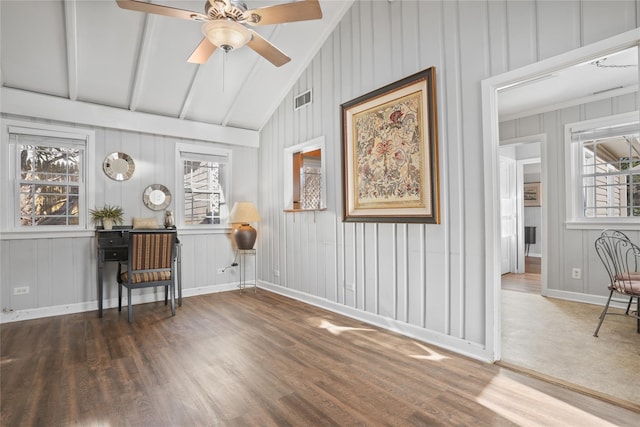 interior space featuring visible vents, baseboards, lofted ceiling with beams, wood finished floors, and a ceiling fan