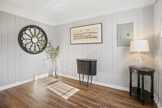 interior space with electric panel, baseboards, and wood finished floors