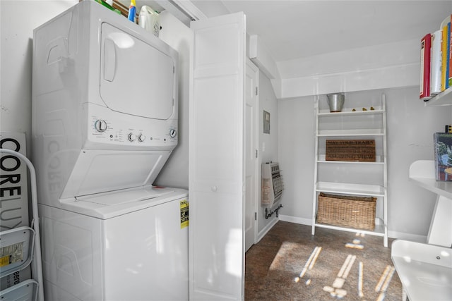 washroom featuring stacked washer / drying machine, heating unit, baseboards, and laundry area