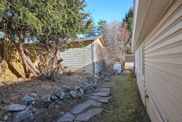 view of property exterior featuring an outbuilding, a storage unit, and fence