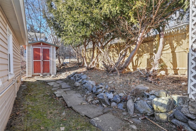 view of yard with a shed, an outdoor structure, and fence