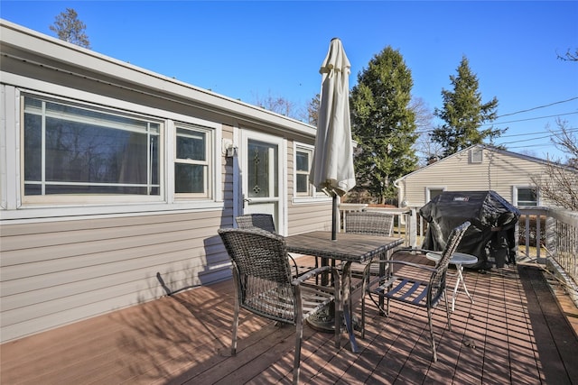 deck with outdoor dining area and a grill