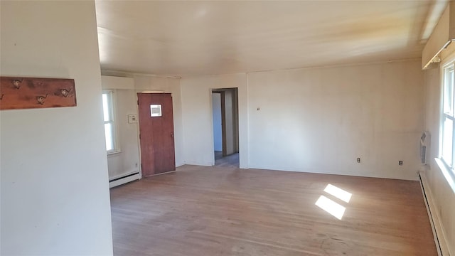 spare room with a baseboard radiator, baseboard heating, and wood finished floors