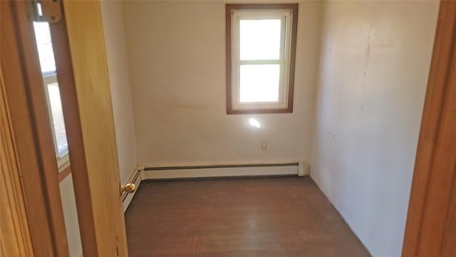 unfurnished room featuring baseboard heating and wood finished floors