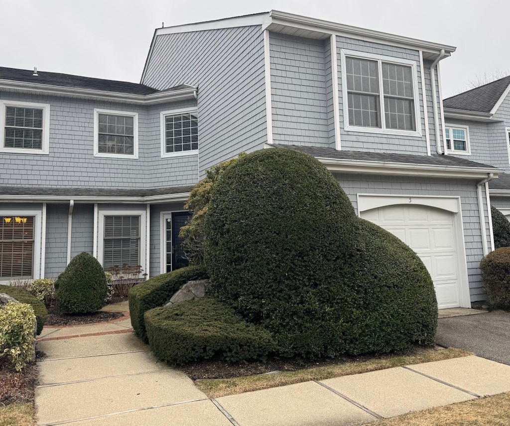 view of property exterior with driveway and an attached garage