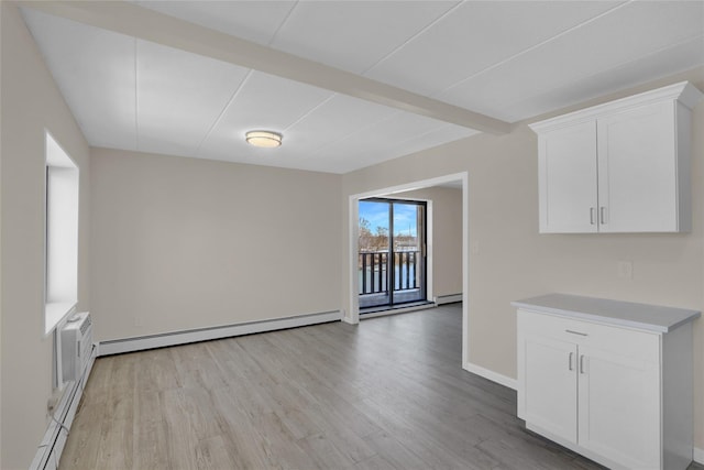 interior space featuring beam ceiling, light wood finished floors, a baseboard radiator, baseboard heating, and baseboards