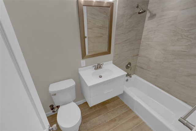 bathroom with shower / bathtub combination, toilet, wood finish floors, vanity, and baseboards