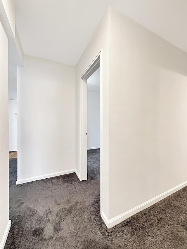 interior space featuring carpet and baseboards