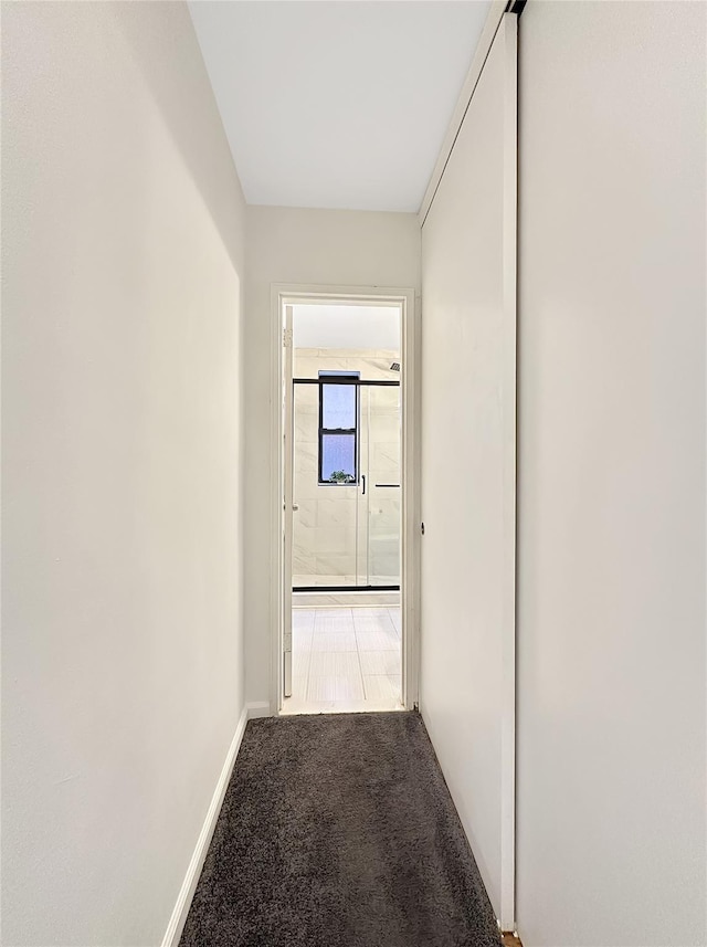 hallway with carpet and baseboards