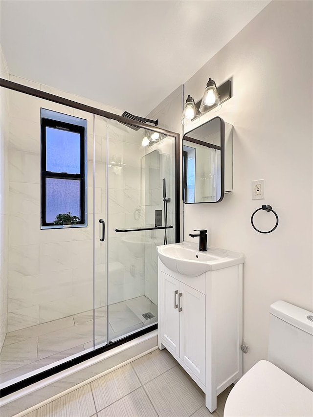 bathroom featuring a stall shower, vanity, and toilet