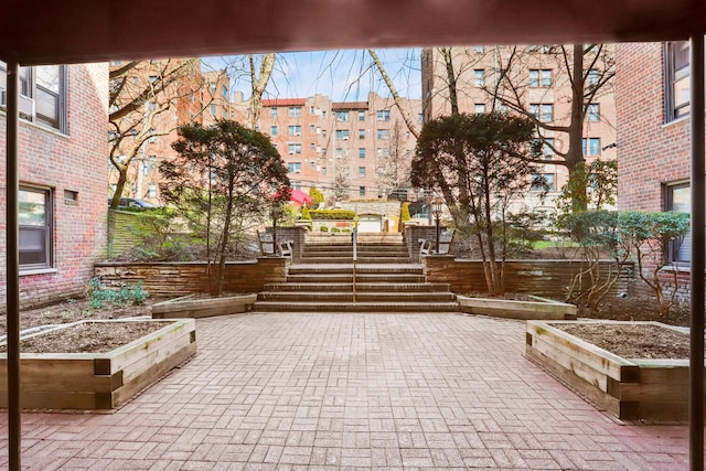 view of property's community featuring a garden and a patio