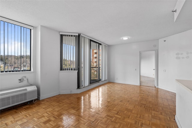 spare room with radiator heating unit, a textured ceiling, and baseboards