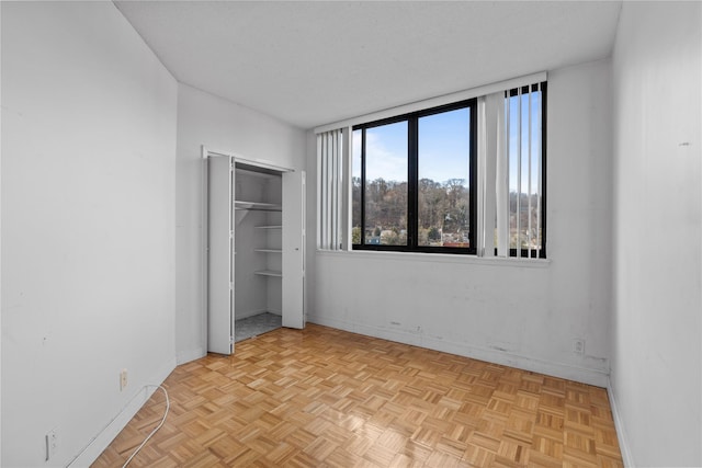 unfurnished bedroom featuring a closet, a textured ceiling, and baseboards