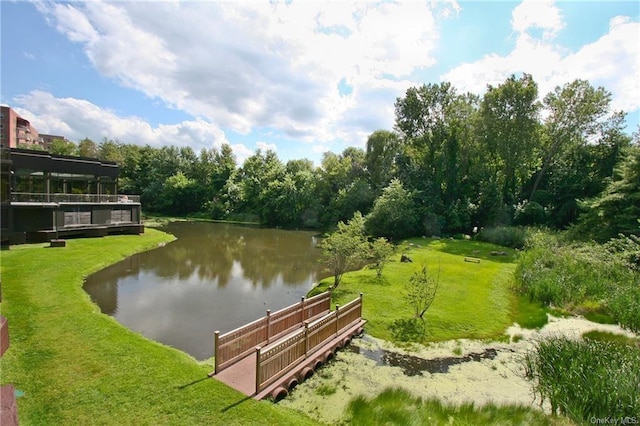 view of property's community with a water view and a yard