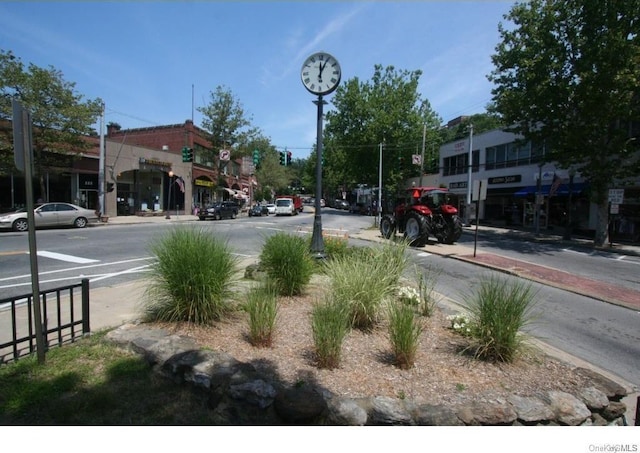 view of road with sidewalks, street lighting, and curbs