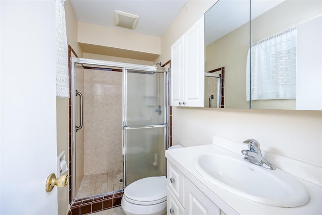 bathroom with toilet, a stall shower, and vanity