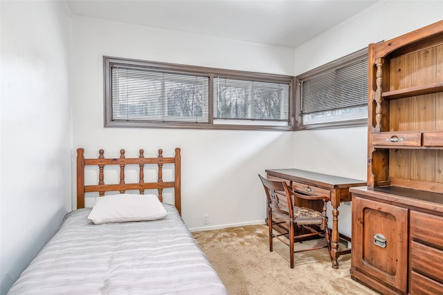 bedroom featuring light colored carpet and baseboards