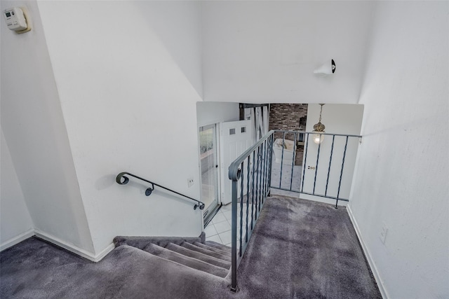 staircase featuring carpet and baseboards