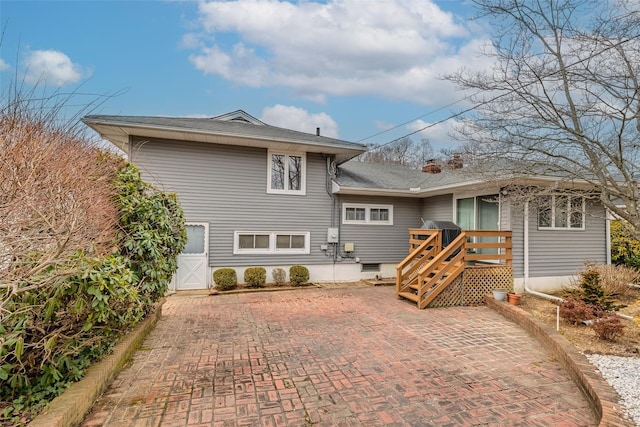 rear view of house featuring a patio area and a chimney