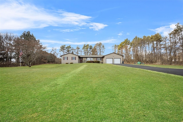 view of front of home with a garage, a front yard, and driveway