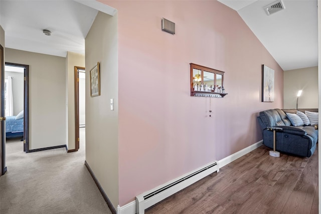 hallway featuring vaulted ceiling, baseboards, visible vents, and baseboard heating