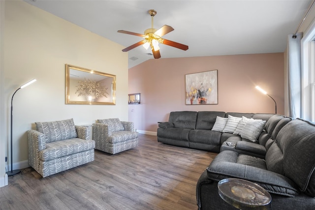 living area featuring baseboards, lofted ceiling, wood finished floors, plenty of natural light, and a ceiling fan