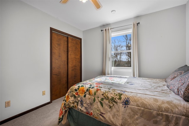 bedroom with a ceiling fan, carpet flooring, baseboards, and a closet