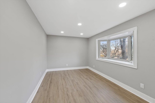 empty room with recessed lighting, wood finished floors, and baseboards