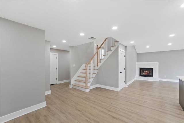 interior space with light wood-style floors, stairs, baseboards, and recessed lighting