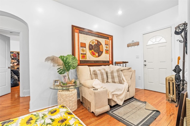 entryway with recessed lighting, arched walkways, and light wood-style floors