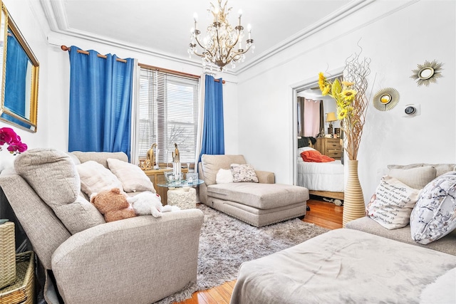 living area with a chandelier, wood finished floors, and ornamental molding