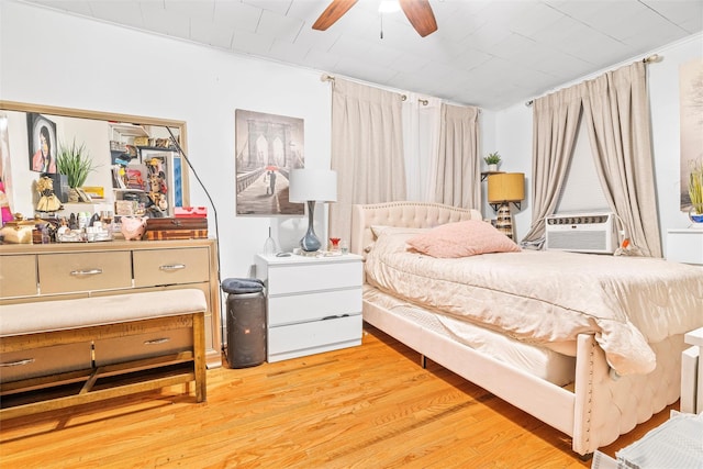 bedroom featuring ceiling fan, cooling unit, and light wood-style floors