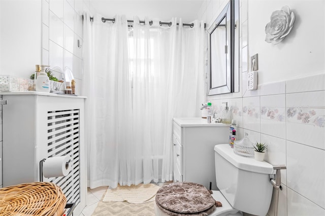 full bathroom featuring vanity, tile walls, toilet, and tile patterned flooring