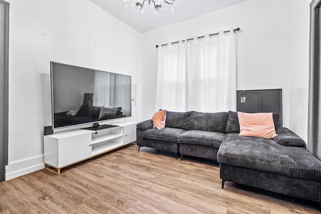 living area with a notable chandelier, baseboards, and wood finished floors