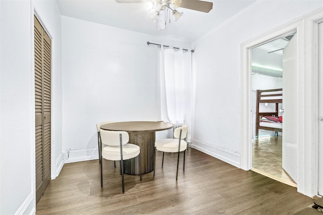 dining area with a ceiling fan, wood finished floors, and baseboards