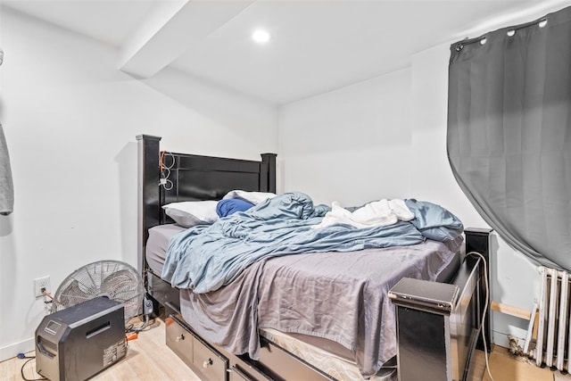 bedroom with recessed lighting, radiator heating unit, baseboards, and wood finished floors