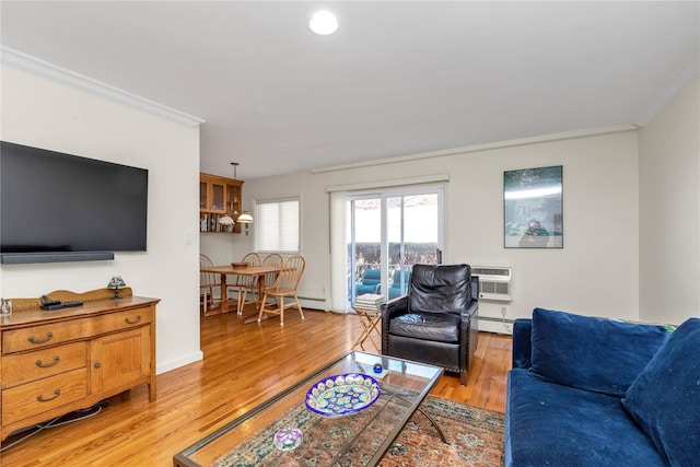 living room featuring crown molding, a baseboard radiator, a wall mounted AC, light wood-type flooring, and baseboards