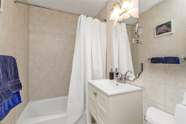 bathroom featuring toilet, shower / bath combo, vanity, and tile walls